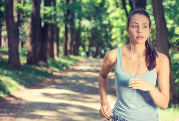 Young woman running In countryside wearing earphones