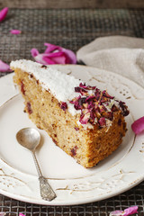 Carrot vegan cake with coconut icing and dried wild rose petals