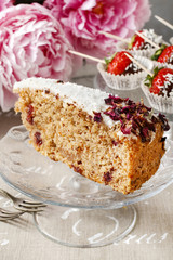 Carrot vegan cake with coconut icing and dried wild rose petals