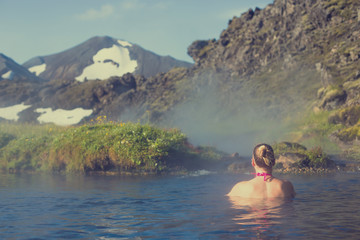 Fototapeta na wymiar Young woman relax in a hot spring in Iceland Landmannalaugar