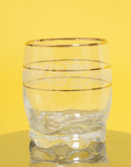 Empty glass on yellow background