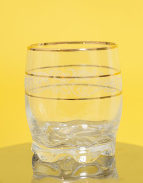 Empty glass on yellow background