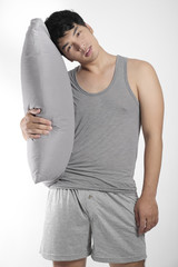 Asian boy in gray pajamas with a pillow