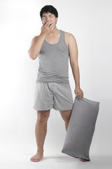 Asian boy in gray pajamas with a pillow