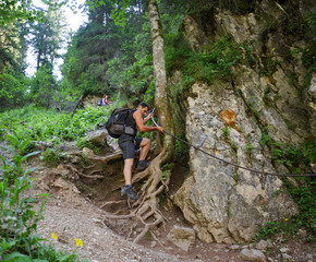 Hikers on a perilous trail, holding the safety line