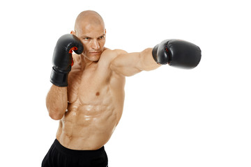 Very fit kickboxer punching on white
