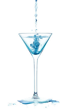 Blue Liquid falling into a cocktail glass of dry martini Isolate