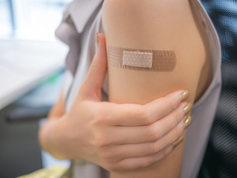 Adhesive Bandage On A Female Arm After Vaccination