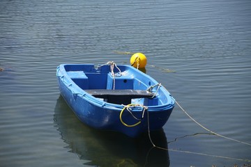 Blauer Ruderboot vor Anker auf dem Wasser