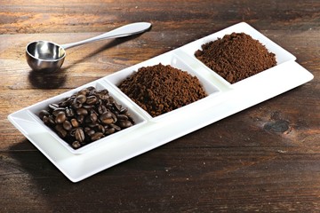 Kaffeebohnen, Kaffeepulver und Instantkaffee auf rustikalem Holztisch