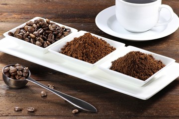 Kaffeebohnen, Kaffeepulver und Instantkaffee auf rustikalem Holztisch