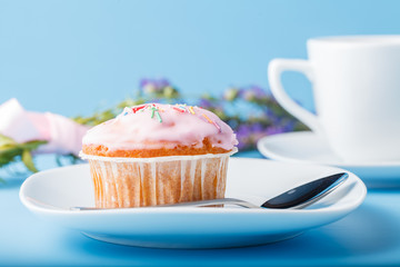 Colorful muffin on saucer with flowers