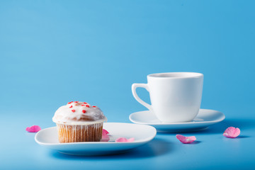Colorful muffin on saucer with flower petal