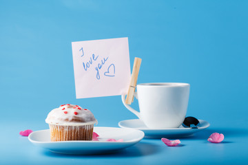Colorful muffin on saucer with flower petal and message 