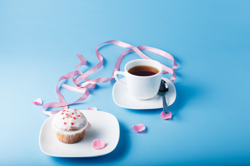 Colorful muffin on saucer with flower petal and message 
