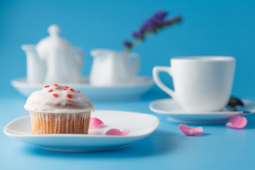 Colorful muffin on saucer with flower petal and message 