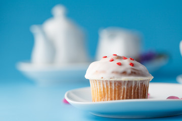 Colorful muffin on saucer with flower petal and message 