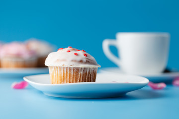 Colorful muffin on saucer with flower petal and message 