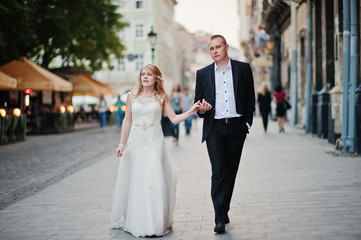 wedding couple walking on streets of city
