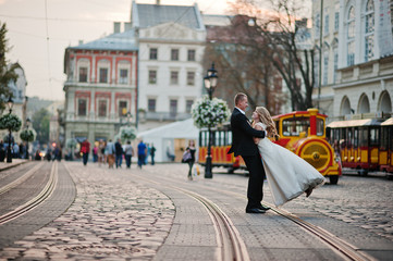 groom hold on hand bride background city with kids train