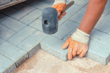 worker set up panel on the road with rubber hammer