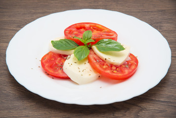 Caprese salad with mozarella cheese, tomatoes and basil