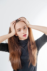 Fototapeta premium Fashion model with long hair in black sweater poses on white