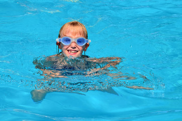Naklejka premium Kind beim schwimmen im pool