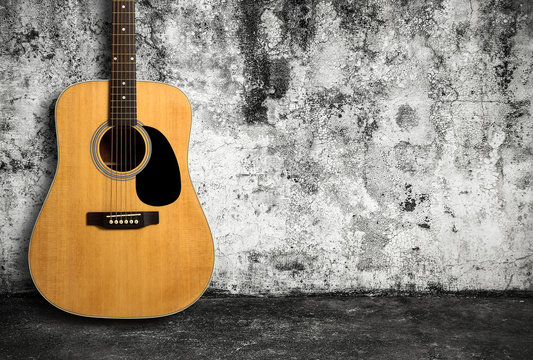 Acoustic guitar against old wall