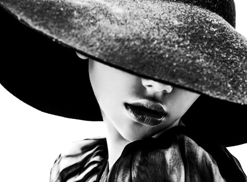 Beautiful woman with full lips in black hat poses on white