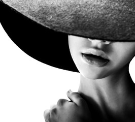 Beautiful woman with full lips in black hat poses on white - 89081286