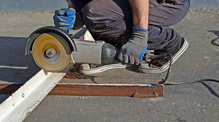 Hands of the mechanic working with the angular grinder