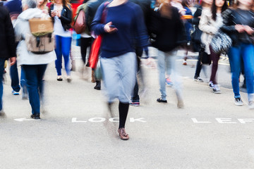 Menschen in Bewegungsunsch&auml;rfe &uuml;berqueren die Stra&szlig;e