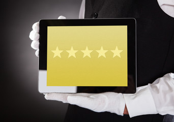 Waiter Showing Rating System On Digital Tablet