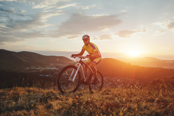 Naklejka na ściany i meble mountain bike cyclist riding track on grass rocky trail above su