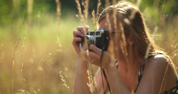 Girl taking photos in nature with vintage camera