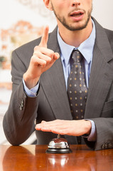 customer ringing hotel bell at reception desk