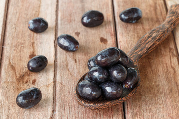 blue grapes on wooden spoon on old rustic table