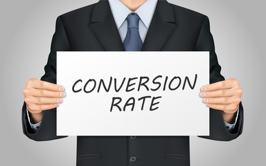 businessman holding conversion rate words poster