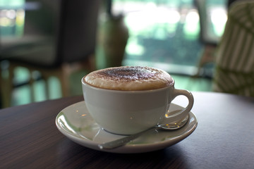 Cup of coffee and a cake on the table in cafe