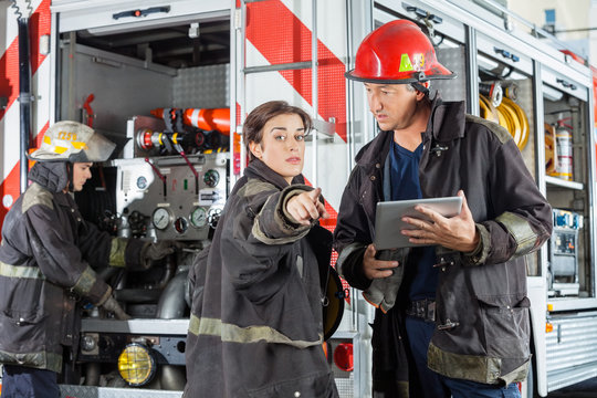 Firefighter Pointing While Colleague Holding Digital Tablet