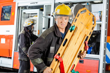 Confident Firefighter Holding Wooden Stretcher