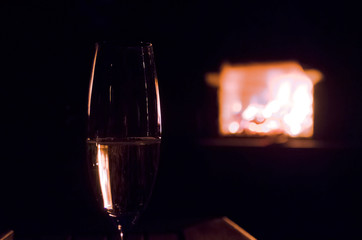 Sektglas vorm Kaminfeuer 