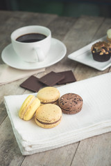 macaroons with coffee on wooden table