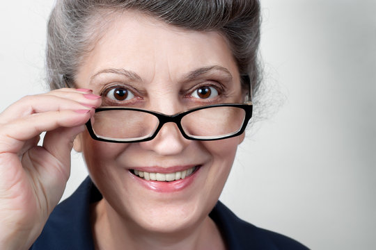Closeup portrait of senior lady wearing glasses, smiling at camera