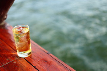A Glass of alcohol with ice beside river