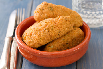 fish croquettes on dish on blue background