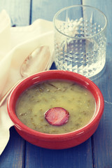 portuguese soup caldo verde in ceramic dish with glass of water