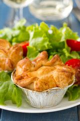 pie with chicken with salad on white plate and glass of wine