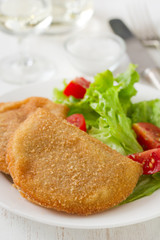 portuguese meat cookies with fresh salad on white dish on white background
